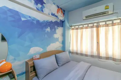 a small bedroom with a bed and a mural at MS Mansion in Bangkok