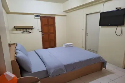 a bedroom with a bed and a flat screen tv at MS Mansion in Bangkok