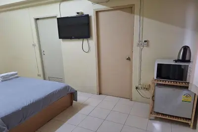 a room with a bed and a television in it at MS Mansion in Bangkok
