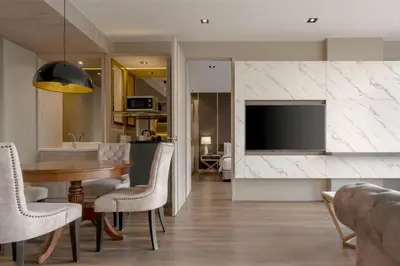 a living room with a dining table and a tv at Zayn Hotel Bangkok - Airport Link Access in Bangkok