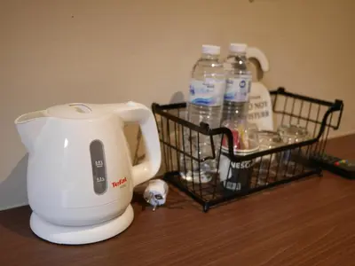 a white blender sitting on a table with bottles of water at Let's Zzz Bangkok in Bangkok