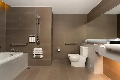 a bathroom with a toilet and a tub and a sink at Hyatt Place Bangkok Sukhumvit 1 in Bangkok