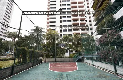 an empty basketball court in a city with tall buildings at Riverine Place Hotel and Residence in Nonthaburi