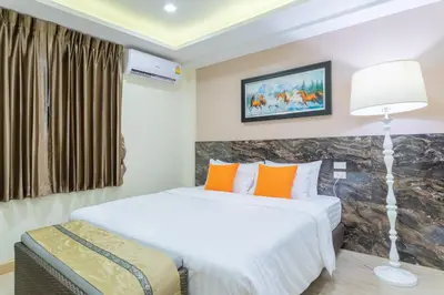 a bedroom with a bed with orange pillows at 4M Pratunam Hotel in Bangkok