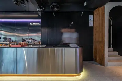 a person is standing behind a counter in a room at The Period Pratunam in Bangkok