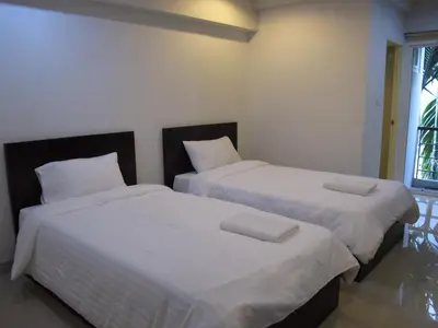 two beds sitting next to each other in a bedroom at Delight Residence in Bangkok