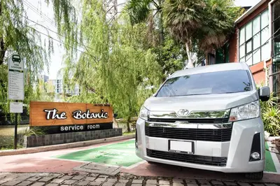 a white van parked in front of a sign at Botanic Service Room at Impact Muangthongthani - SHA Certified in Nonthaburi