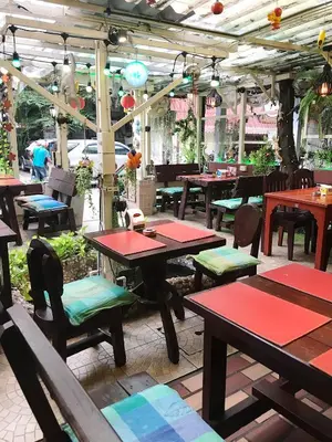a restaurant with wooden tables and chairs at Honey House1 hotel in Bangkok