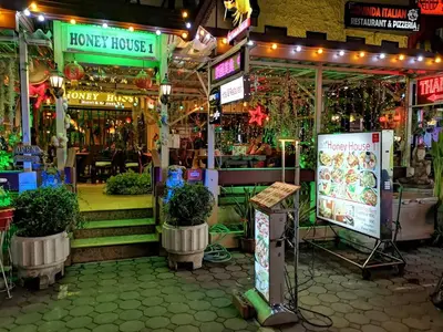 a grocery store with potted plants in front of it at Honey House1 hotel in Bangkok