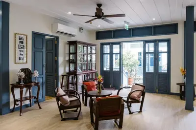 a living room with chairs and a table at Baan Vajra in Bangkok