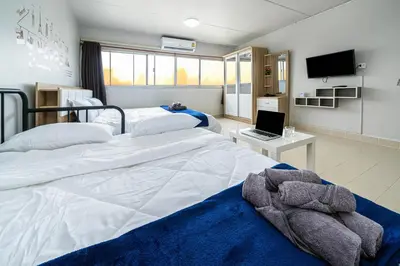 a bedroom with two beds and a laptop on a table at Popular Condo Muangthong by Khun Eve in Nonthaburi