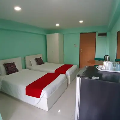 a hotel room with two beds and a counter at SLT Apartment Bangkok in Bangkok