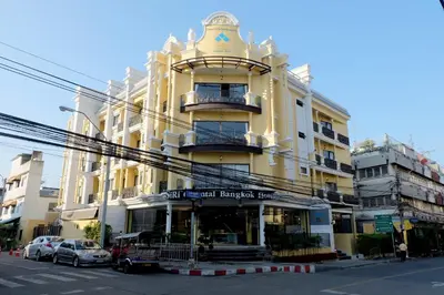 a large yellow building on a city street at Siri Oriental Bangkok Hotel in Bangkok