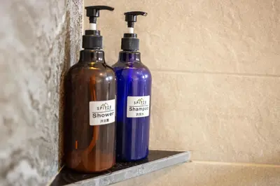 two bottles of alcohol are sitting on a shelf at Spittze Hotel Pratunam in Bangkok