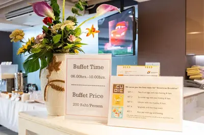 a table with two boxes and a vase with flowers at Spittze Hotel Pratunam in Bangkok