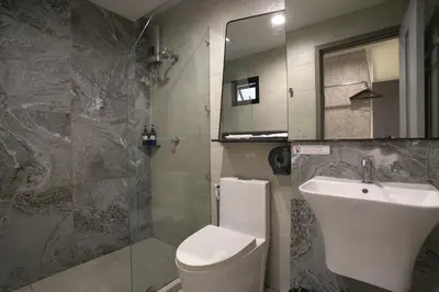 a bathroom with a toilet and a sink and a mirror at Spittze Hotel Pratunam in Bangkok