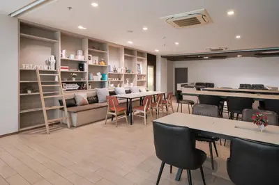 a restaurant with tables and chairs in a room at Samyan Serene Hotel in Bangkok