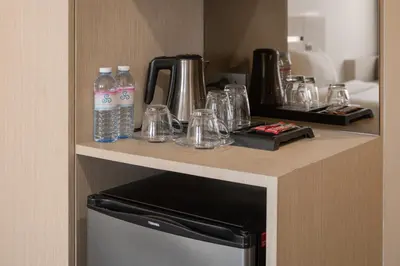 a counter with bottles of water and glasses on it at Samyan Serene Hotel in Bangkok