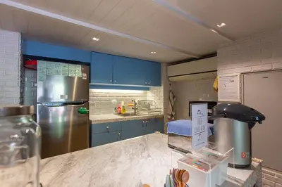 a kitchen with blue cabinets and a stainless steel refrigerator at Simply Sleep Hostel in Bangkok