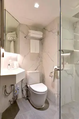 a bathroom with a toilet and a sink and a shower at Syama Nana in Bangkok