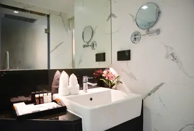 a bathroom with a white sink and a mirror at Syama Nana in Bangkok