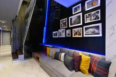 a living room with a couch and pictures on the wall at Syama Nana in Bangkok
