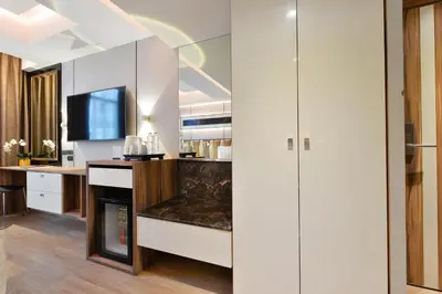 a kitchen with white cabinets and a fireplace at Syama Nana in Bangkok