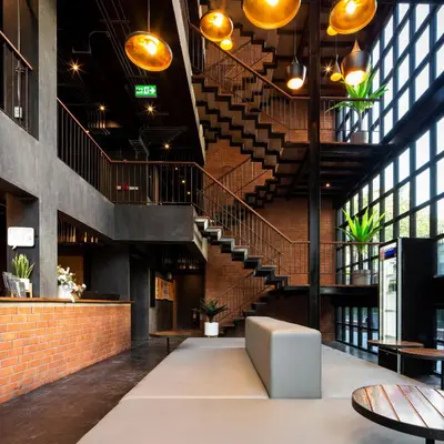 a lobby of a building with a spiral staircase at BED STATION Hostel Khaosan in Bangkok
