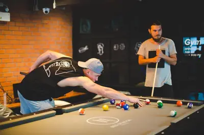 a man playing a game of pool on a table at BED STATION Hostel Khaosan in Bangkok