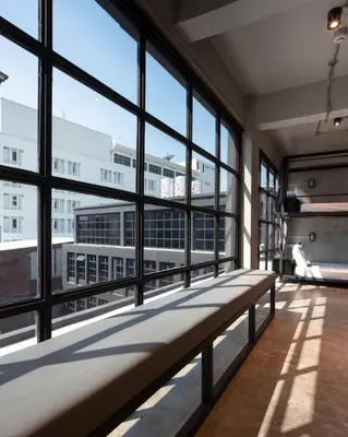 a large room with windows and a bench in a building at BED STATION Hostel Khaosan in Bangkok