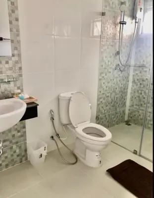 a bathroom with a toilet and a shower and a sink at The Lux Ladprao 10 in Bangkok