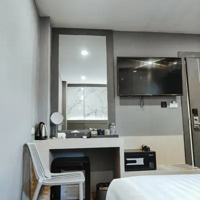 a hotel room with a bed and a tv on the wall at Hyde Park Hotel Bangkok in Bangkok