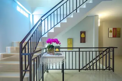 a staircase with a table with a vase of flowers on it at Penyos Residence in Bangkok