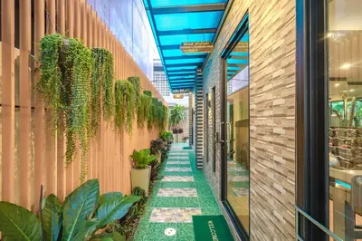 a walkway with plants on the side of a building at Penyos Residence in Bangkok