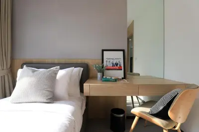 a bedroom with a bed and a desk and a chair at Alix Bangkok Hotel in Bangkok