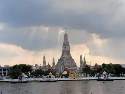 a large white building next to a body of water at Arun Residence in Bangkok