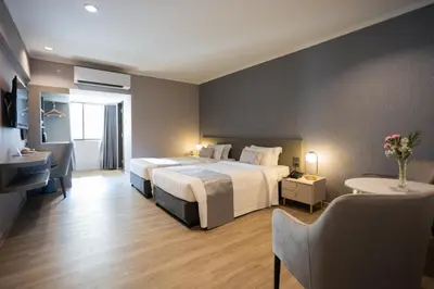 a large hotel room with two beds and a desk at S.D. Avenue Hotel in Bangkok