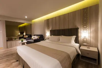 a bedroom with a large bed and a living room at S.D. Avenue Hotel in Bangkok