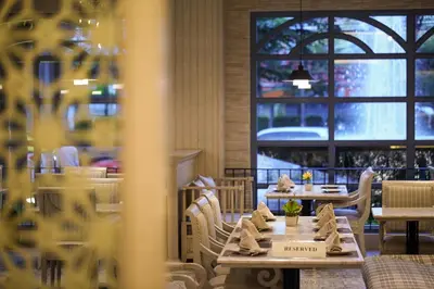 a restaurant with tables and chairs and a window at S.D. Avenue Hotel in Bangkok