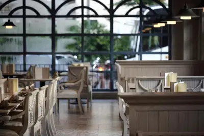 a dining room with chairs and tables and windows at S.D. Avenue Hotel in Bangkok