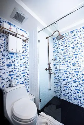 a bathroom with a toilet and a shower at Dhevi Bangkok Hotel in Bangkok