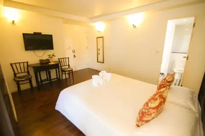 a hotel room with a bed and a television at SSIP Boutique Dhevej Bangkok in Bangkok