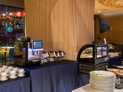 a table with cups and plates on top of it at VELA Dhi GLOW Pratunam in Bangkok