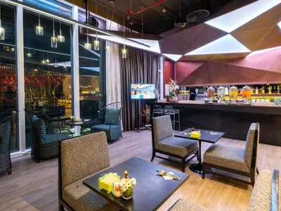 a restaurant with tables and chairs and a bar at VELA Dhi GLOW Pratunam in Bangkok