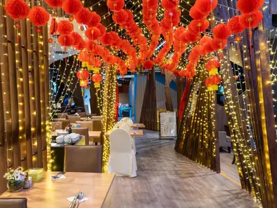 a banquet hall with red flowers and lights at VELA Dhi GLOW Pratunam in Bangkok