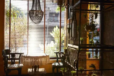 a room with a window with chairs and a table at Old Capital Bike Inn - SHA Certified in Bangkok