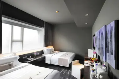 a bedroom with two beds and a large window at Mode Sathorn Hotel in Bangkok