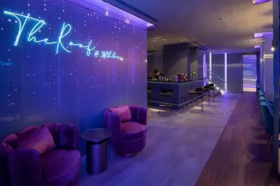 a room with purple chairs and a bar at Mode Sathorn Hotel in Bangkok
