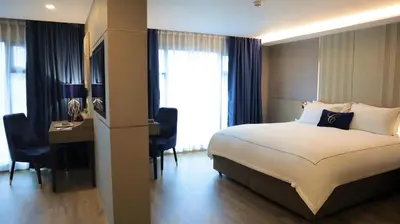 a hotel room with a bed and a desk at GLOW Sukhumvit 5 in Bangkok