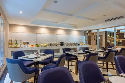 a restaurant with blue chairs and tables and a counter at GLOW Sukhumvit 5 in Bangkok
